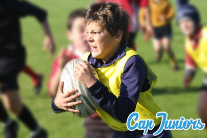 Un jeune joueur tient son ballon de rugby avec détermination