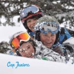 3 gamins jouent dans la poudreuse, casques et lunettes de ski bien en place