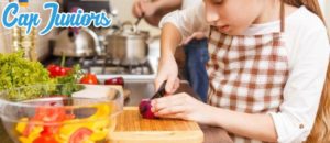 Une petite fille prépare un plat cuisiné en atelier cuisine, une colonie activité manuelle